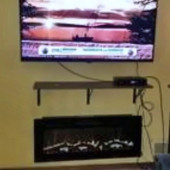TV and floating shelf above an electric fireplace