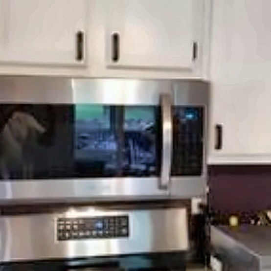 Microwave fitted between white cabinets